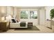 Airy bedroom with large windows offering views of the verdant outdoors, and a sleek dresser and ottoman at 809 Tundra Loop, Groveland, FL 34736
