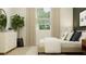 Bright bedroom with a comfortable bed, neutral color scheme, and a large window with leafy views at 809 Tundra Loop, Groveland, FL 34736