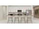Modern kitchen with white cabinets, stainless steel appliances, and an island with seating at 809 Tundra Loop, Groveland, FL 34736