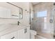 Modern bathroom featuring a walk-in shower, vanity with white countertop and dark hardware, and frameless mirror at 811 E Mcdonald Ave, Eustis, FL 32726