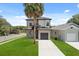A gray two-story home with a one-car garage, a well-kept lawn, and a paved driveway at 811 E Mcdonald Ave, Eustis, FL 32726