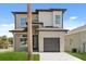 A contemporary two-story home with a gray exterior, a one-car garage, and a well-manicured lawn at 811 E Mcdonald Ave, Eustis, FL 32726