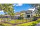 Fenced backyard featuring a well-maintained lawn, mature trees, and refreshing swimming pool at 8256 Bayview Crossing Dr, Winter Garden, FL 34787