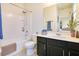 Bathroom features dark vanity cabinets, a large mirror, and a shower-tub combo at 8256 Bayview Crossing Dr, Winter Garden, FL 34787