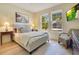 Cozy bedroom featuring a bed, side tables, and natural light from two windows at 8256 Bayview Crossing Dr, Winter Garden, FL 34787