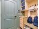 Well-organized mudroom featuring a custom storage bench, cubbies, and decorative wall paneling at 8256 Bayview Crossing Dr, Winter Garden, FL 34787