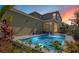 Sparkling pool with illuminated water features is surrounded by colorful landscaping and a cozy patio area at 8256 Bayview Crossing Dr, Winter Garden, FL 34787