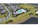 Aerial view of a community pool with lounge chairs, palm trees, clubhouse, parking, and nearby green space at 8256 Bayview Crossing Dr, Winter Garden, FL 34787