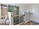 A bright landing area with decor, a modern light fixture, and a safety gate at the stairs at 8256 Bayview Crossing Dr, Winter Garden, FL 34787