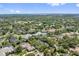 Aerial view of houses surrounded by mature trees with a water view in the distance at 8612 Summerville Pl, Orlando, FL 32819