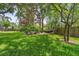 Relaxing backyard with hammock strung between trees and well manicured lawn at 8612 Summerville Pl, Orlando, FL 32819