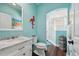 Aqua bathroom featuring a double sink, marble vanity, glass shower, and decorative flamingo wall art at 8612 Summerville Pl, Orlando, FL 32819
