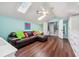 A bonus room features a brown leather sofa, a ceiling fan and lots of light at 8612 Summerville Pl, Orlando, FL 32819