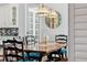Charming dining room featuring a wooden table, comfortable seating, stylish lighting, and a decorative wall clock at 8612 Summerville Pl, Orlando, FL 32819