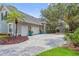 Spacious driveway leading to a three-car garage, enhanced by colorful landscaping at 8612 Summerville Pl, Orlando, FL 32819