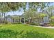 Beautifully landscaped single-Gathering home with a lush green lawn, mature trees, and well-maintained exterior at 8612 Summerville Pl, Orlando, FL 32819