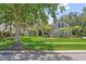 Inviting single-Gathering home with lush green lawn, mature trees, and colorful landscaping at 8612 Summerville Pl, Orlando, FL 32819