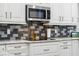 Kitchen detail with stainless steel microwave and mosaic backsplash at 8612 Summerville Pl, Orlando, FL 32819