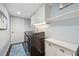 Well-organized laundry room with white cabinets, modern washer and dryer, and a bright overhead light at 8612 Summerville Pl, Orlando, FL 32819