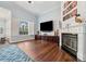 Bright living room with hardwood floors, fireplace, large TV, and plenty of natural light from the windows at 8612 Summerville Pl, Orlando, FL 32819