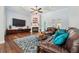 Spacious living room features a ceiling fan, fireplace, hardwood floors, comfortable seating, and bright windows at 8612 Summerville Pl, Orlando, FL 32819