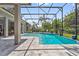 A lovely view of the screened-in pool area with tiled deck and tropical landscaping at 8612 Summerville Pl, Orlando, FL 32819