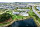 Aerial view of community clubhouse, pool, parking and ponds in a neighborhood filled with houses at 6231 Atkinson Ln, The Villages, FL 32163