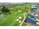 Aerial view of the community golf course next to a neighborhood with water features and solar panels at 6231 Atkinson Ln, The Villages, FL 32163
