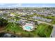 Overhead view of neighborhood with community pool, clubhouse, parking, shuffleboard court, and pond on a sunny day at 6231 Atkinson Ln, The Villages, FL 32163