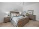 Bright bedroom featuring a bed with decorative pillows, two side tables, and a matching dresser at 6231 Atkinson Ln, The Villages, FL 32163