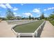 Well-maintained bocce ball court surrounded by a concrete walkway and picturesque landscaping at 6231 Atkinson Ln, The Villages, FL 32163
