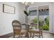 Cozy dining area with a glass-top table, wicker chairs, and a view to the backyard at 6231 Atkinson Ln, The Villages, FL 32163