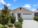 Inviting home with an attached garage, lush green bushes, and a well-manicured lawn at 6231 Atkinson Ln, The Villages, FL 32163