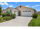 Charming single-story home featuring an attached garage, well-maintained lawn, and mature landscaping at 6231 Atkinson Ln, The Villages, FL 32163