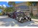 Row of golf carts parked near the Sawgrass Grove building on a sunny day at 6231 Atkinson Ln, The Villages, FL 32163