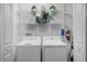 Functional laundry room equipped with shelving, washer, and dryer, maximizing space and organization at 6231 Atkinson Ln, The Villages, FL 32163