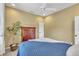 Charming bedroom with a blue quilt bed, wood cabinet, ceiling fan and a beautiful houseplant in the corner at 1017 Parkside Pointe Blvd, Apopka, FL 32712