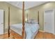 Primary bedroom features a four-poster bed, hardwood flooring, stylish window treatments, and elegant furnishings at 1017 Parkside Pointe Blvd, Apopka, FL 32712