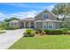 Charming two-story home features a manicured lawn, lush landscaping, and a welcoming entrance with arched windows at 1017 Parkside Pointe Blvd, Apopka, FL 32712