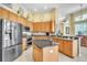 Modern kitchen with stainless steel appliances, wooden cabinets, and a central island at 1017 Parkside Pointe Blvd, Apopka, FL 32712