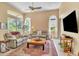 Comfortable living room with natural lighting, ceiling fan, neutral colored furniture, and tile floors at 1017 Parkside Pointe Blvd, Apopka, FL 32712