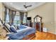 Serene main bedroom suite with hardwood floors, decorative curtains, and backyard views at 1017 Parkside Pointe Blvd, Apopka, FL 32712