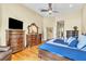 Main bedroom featuring hardwood floors, a ceiling fan, dresser, and views to the en-suite bathroom at 1017 Parkside Pointe Blvd, Apopka, FL 32712
