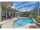 Outdoor screened-in pool with a lounge chairs, seating, and a serene lake view at 1017 Parkside Pointe Blvd, Apopka, FL 32712