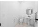 Clean half bathroom featuring a pedestal sink, toilet, and neutral tile flooring at 103 Odin Dr, Winter Haven, FL 33884