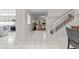 Hallway with stairs leading to an open living room and kitchen area with bright tile floors at 103 Odin Dr, Winter Haven, FL 33884