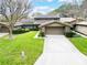 Charming brick home with a well-manicured lawn, mature trees, and a two-car garage at 103 Odin Dr, Winter Haven, FL 33884