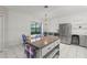 Kitchen with island, stainless steel refrigerator, and white cabinets at 103 Odin Dr, Winter Haven, FL 33884