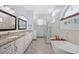 Bright bathroom with dual sinks, granite countertops, and a freestanding tub at 1107 Almond Tree Cir, Orlando, FL 32835