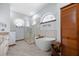 Bright bathroom with shower, freestanding tub, and arched window at 1107 Almond Tree Cir, Orlando, FL 32835